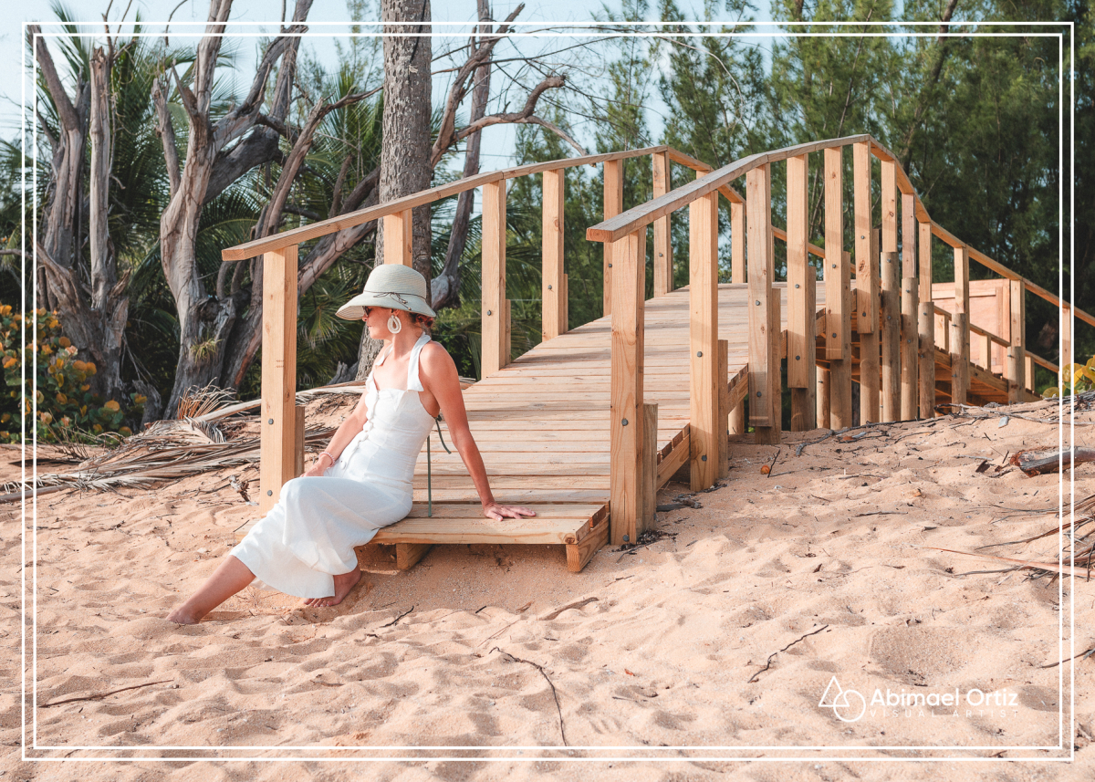 Modelo sentada en el paseo tablado de la playa